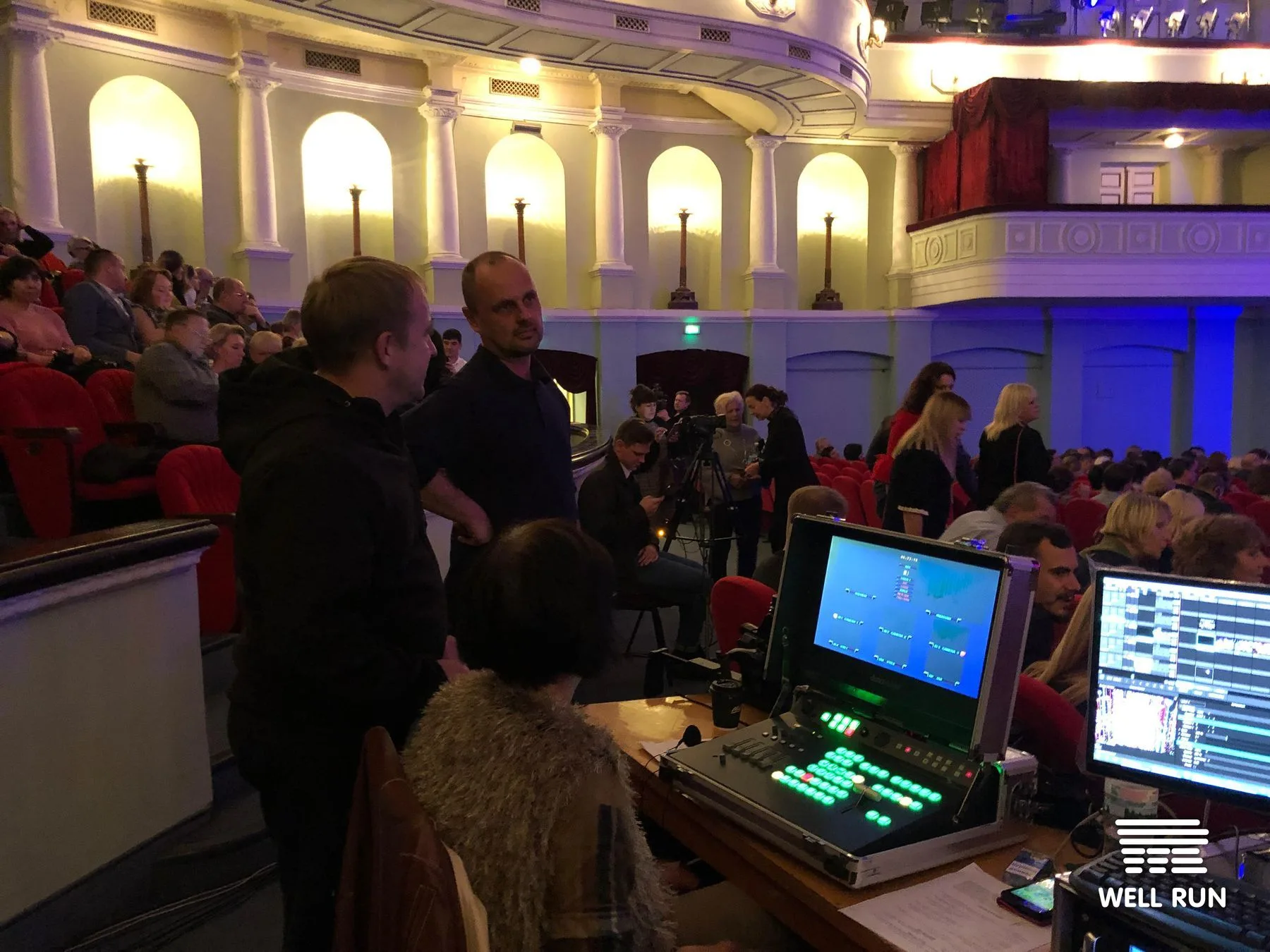 Crew at Datavideo vision mixer in October Palace auditorium, monitors live, audience filling seats