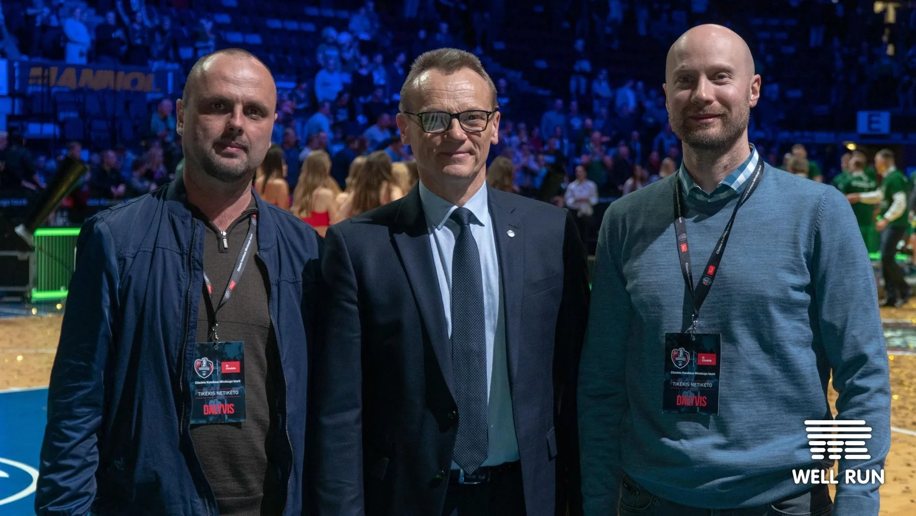 Three men standing courtside at Švyturys Arena during the 2020 Citadele King Mindaugas Cup Final Four — frame 10