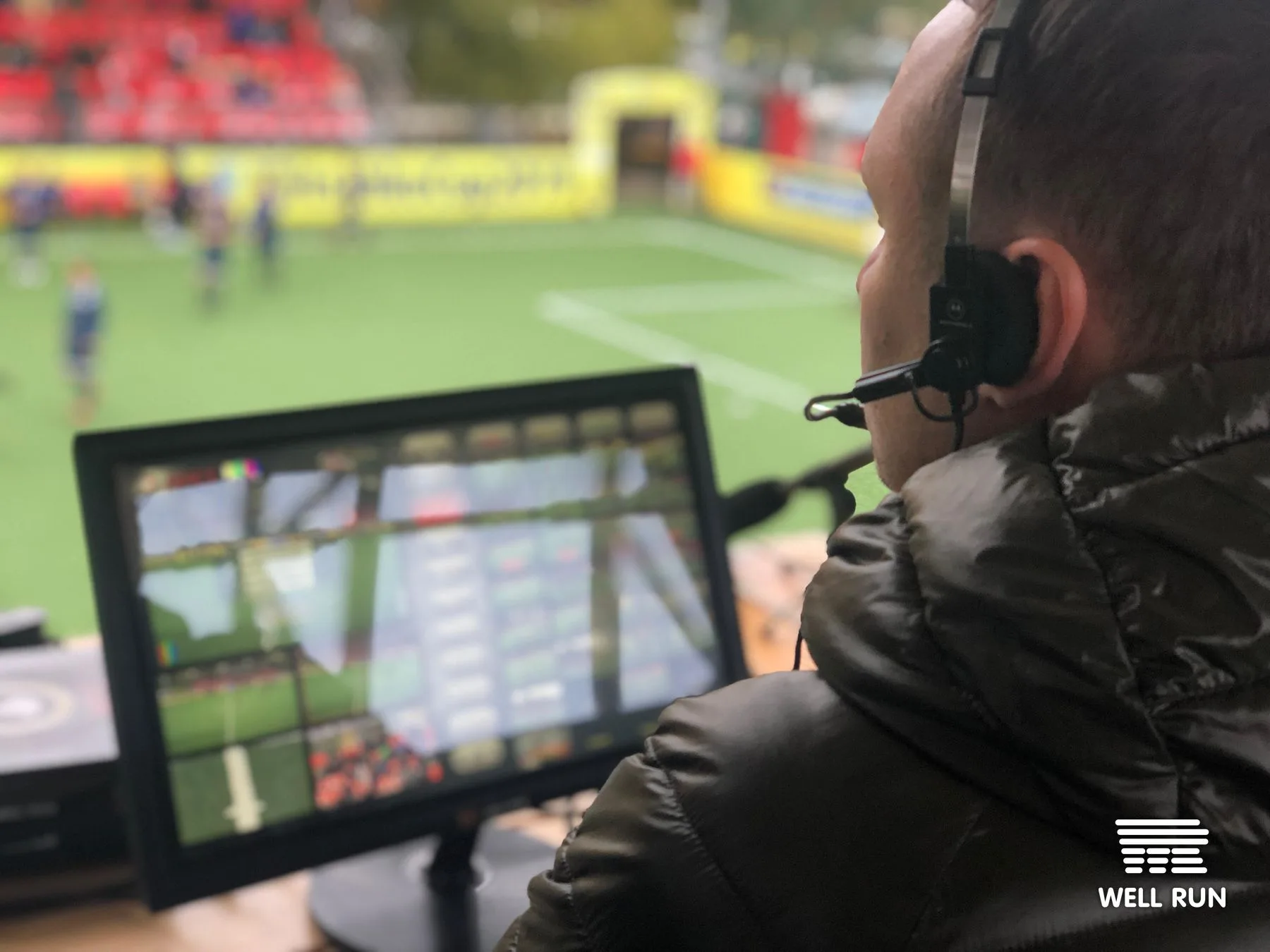 Dmytro Apilat wearing headset watches multiview monitor overlooking Hydropark Arena Superball pitch