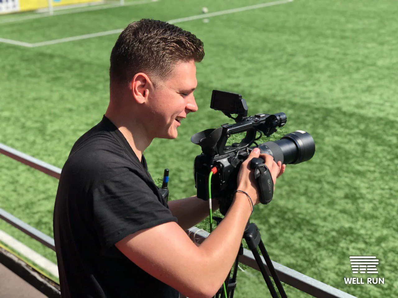 Semen Ponomarenko smiling while operating a Sony camera on tripod at Hydropark Arena, Kyiv — frame 5